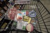 An assortment of vegan, organic, locally sourced and wild caught food products sit in a shopping cart at a grocery store in New Orleans, Wednesday, April 17, 2024. (AP Photo/Gerald Herbert, File)