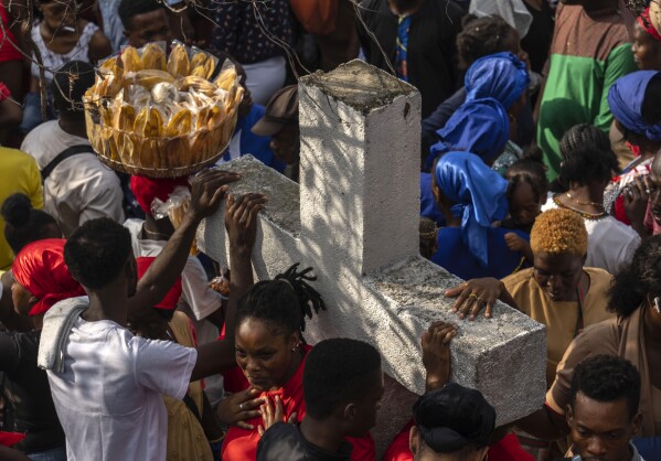 FILE - Vodou pilgrims gather round a cross during the Saint George celebration in Port-au-Prince, Haiti, April 24, 2024. Shunned publicly by politicians and intellectuals for centuries, Vodou is transforming into a more powerful and accepted religion across Haiti, where its believers were once persecuted. (AP Photo/Ramon Espinosa, File)