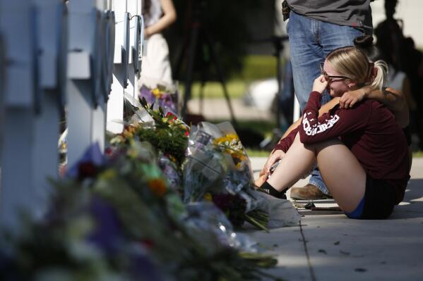 A woman reacts as she pays her respects at a memorial site for the victims killed in this week's elementary school shooting in Uvalde, Texas, Thursday, May 26, 2022. (AP Photo/Dario Lopez-Mills)