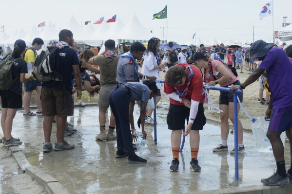 Attendees of the World Scout Jamboree cool off with water at a scout camping site in Buan, South Korea, Friday, Aug. 4, 2023. More than 4,000 British Scouts will leave the World Scout Jamboree at a campsite in South Korea and move into hotels this weekend, the U.K. Scout Association said Friday, as concerns grow after more than 100 participants were treated for heat-related ailments. (Kim-yeol/Newsis via AP)
