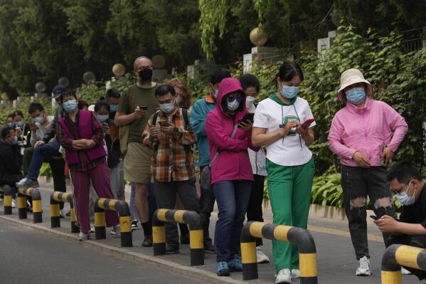 Residents wearing masks line up for mass COVID testing in Chaoyang District on Monday, April 25, 2022, in Beijing. (AP Photo/Ng Han Guan)