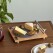 This image released by Uncommon Goods shows a cheese board designed to look like the most expensive, slick turntable, featuring a slate platter and hidden slicer in the one arm. (Uncommon Goods via AP)