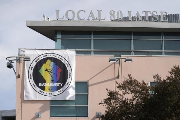 A poster advocating union solidarity hangs from the office building housing The International Alliance of Theatrical Stage Employees Local 80, Monday, Oct. 4, 2021, in Burbank, Calif. The IATSE overwhelmingly voted to authorize a strike for the first time in its 128-year history. (AP Photo/Chris Pizzello)