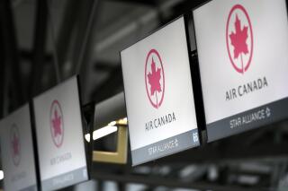 FILE - This May 16, 2020 file photo shows Air Canada check screens at Ottawa International Airport in Ottawa, Ontario, Canada.   The U.S. government is seeking to fine Air Canada more than $25 million over what it says have been slow refunds for passengers whose flights were canceled since the pandemic started. The Transportation Department said Tuesday, June 15, 2021,  it has received more than 6,000 consumer complaints about Air Canada since March of last year. (Justin Tang/The Canadian Press via AP)