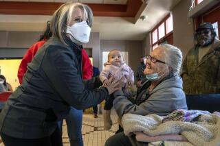 New Mexico Gov. Michelle Lujan Grisham, left, talks Connie Guinn and her granddaughter, Bella Guerrero Munoz, at the emergency evacuation center in Las Vegas, Monday April 25, 2022. The Calf Canyon Fire has forced the evacuation of Guinn and her family, from Laboux, and many residents of San Miguel and Mora County. (Eddie Moore/The Albuquerque Journal via AP)