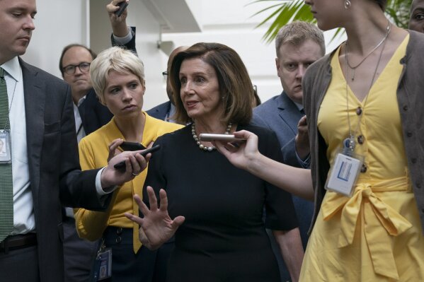 Speaker of the House Nancy Pelosi, D-Calif., is surrounded by reporters as she arrives to meet with her caucus the morning after declaring she will launch a formal impeachment inquiry against President Donald Trump, at the Capitol in Washington, Wednesday, Sept. 25, 2019. (AP Photo/J. Scott Applewhite)