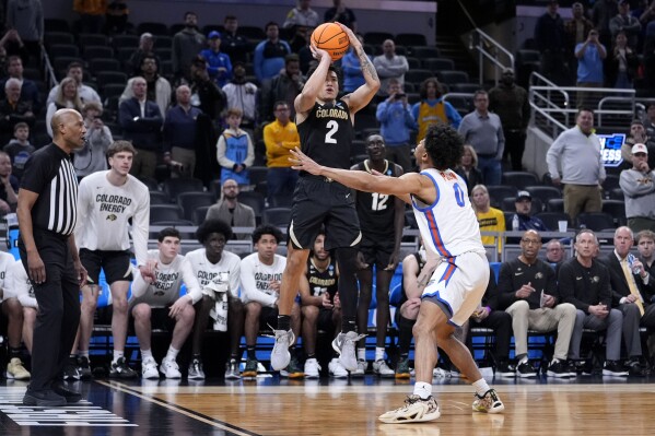 Colorado guard KJ Simpson (2) shoots over Florida guard Zyon Pullin (0) at the end of a first-round college basketball game in the NCAA Tournament, Friday, March 22, 2024, in Indianapolis. Colorado won 102-100. (AP Photo/Michael Conroy)