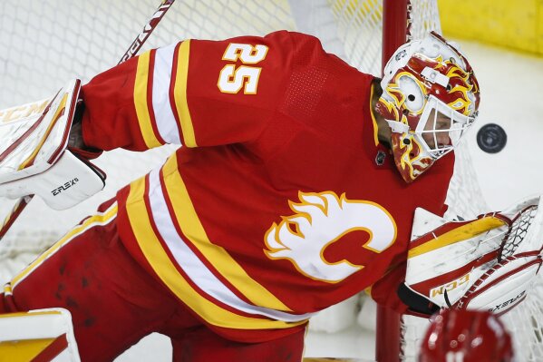 Calgary Flames goalie Jacob Markstrom eyes the puck  during the third period of the team's NHL hockey game against the Vancouver Canucks on Saturday, Jan. 16, 2021, in Calgary, Alberta. (Jeff McIntosh/The Canadian Press via AP)