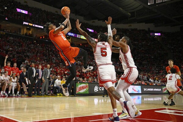 Illinois guard Terrence Shannon Jr. (0) shoots against Maryland guard DeShawn Harris-Smith (5) and forward Julian Reese, third from left, during the first half of an NCAA college basketball game, Saturday, Feb. 17, 2024, in College Park, Md. (AP Photo/Nick Wass)