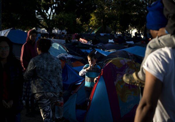 
              A young member of a migrant caravan brushes his teeth inside his tent at the Benito Juarez Sports Center that is serving as a shelter for migrants in Tijuana, Mexico, Monday, Nov. 26, 2018. The mayor of Tijuana has declared a humanitarian crisis in his border city and says that he has asked the United Nations for aid to deal with thousands of Central American migrants who have arrived. (AP Photo/Ramon Espinosa)
            