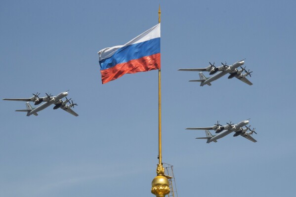 Russian Tu-95 strategic bombers fly past a Russian flag at the Kremlin complex during a rehearsal for the Victory Day military parade in Moscow, Russia, May 4, 2018. (AP Photo/Pavel Golovkin, File)
