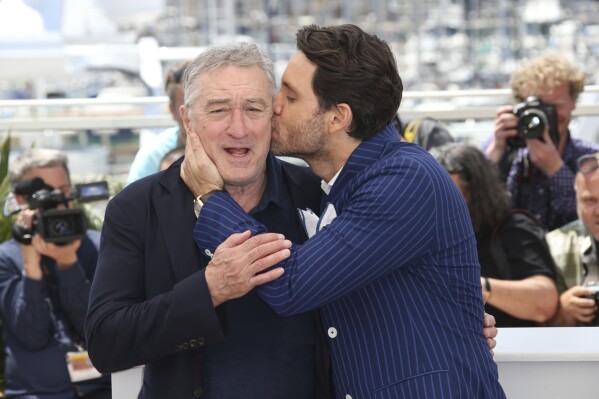 Actor Edgar Ramirez, right, kisses fellow actor Robert De Niro during a photo call for "Hands of Stone" at the 69th international film festival, Cannes, southern France on May 16, 2016. (AP Photo/Joel Ryan, File)