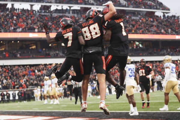 Oregon State tight end Jack Velling, center, celebrates after scoring a touchdown against UCLA with Silas Bolden, left, and Deshaun Fenwick, right, during the first half of an NCAA college football game Saturday, Oct. 14, 2023, in Corvallis, Ore. (AP Photo/Amanda Loman)