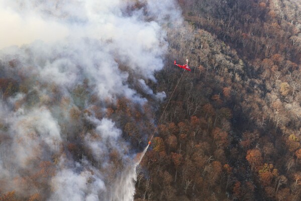 This photo provided by Virginia Department of Forestry shows firefighters trying to stop the western spread of the Quaker Run Wildfire in Madison County, Va. The state Department of Forestry said a wildfire near Madison County has led officials to encourage some residents to evacuate as crews work to stop the blaze from spreading. That fire had burned nearly 2,500 acres (1,012 hectares) on Sunday, but no structures have been affected and firefighters were installing additional fire lines to maintain that, the agency said. (Virginia Department of Forestry via AP)