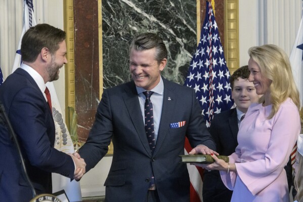 Vice President JD Vance, from left, swears in Pete Hegseth to be Secretary of Defense as his wife Jennifer Rauchet holds the Bible and Hegseth's son watches in the Indian Treaty Room of the Eisenhower Executive Office Building on the White House campus in Washington, Saturday, Jan. 25, 2025. (AP Photo/Rod Lamkey, Jr.)