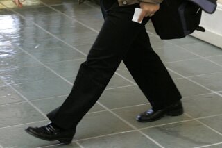 FILE - In this Nov. 5, 2007 file photo, Los Angeles Dodgers assistant general manager Kim Ng walks through the hotel lobby during the first day of Major League Baseball annual general managers meetings in Orlando, Fla. Ng has become the highest-ranking woman in baseball operations in the major leagues. She was hired Friday, Nov. 13, 2020, as general manager of the Miami Marlins. (AP Photo/John Raoux, file)