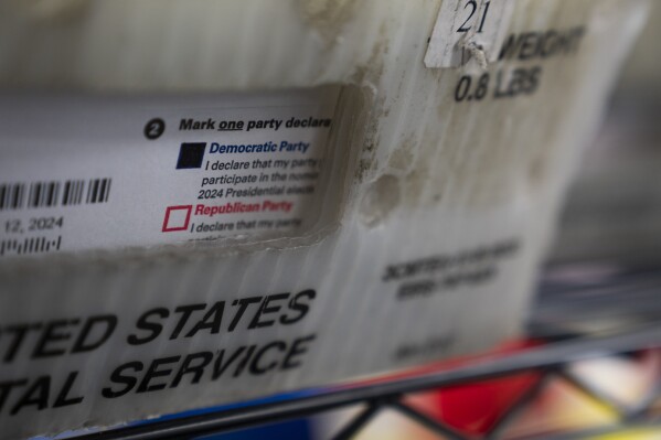 FILE - Vote-by-mail ballots for the presidential primary election are seen on March 12, 2024, at the Clark County Elections Office in Vancouver, Wash. At rallies and in social media posts, former President Donald Trump has been trying to assure Republican voters that casting ballots by mail and other forms of early voting are “all good options.” (AP Photo/Jenny Kane, File)