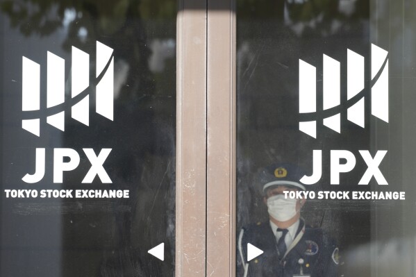 A security guard stand guards at a door of Tokyo Stock Exchange Thursday, Nov. 9, 2023, in Tokyo. Shares were mostly lower in Asia on Thursday, Nov. 23, after a modest advance on Wall Street that kept the market on track for a fourth straight weekly gain.(AP Photo/Eugene Hoshiko)