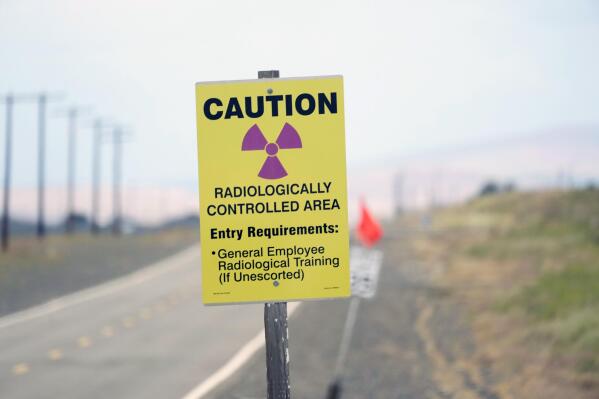 FILE - A caution sign is shown on a road on the Hanford Nuclear Reservation on June 2, 2022. A deal to address two nuclear waste storage tanks that are leaking radioactive materials into the soil on the reservation in Washington state has been reached between Washington state and the U.S. Department of Energy. (AP Photo/Ted S. Warren, File)