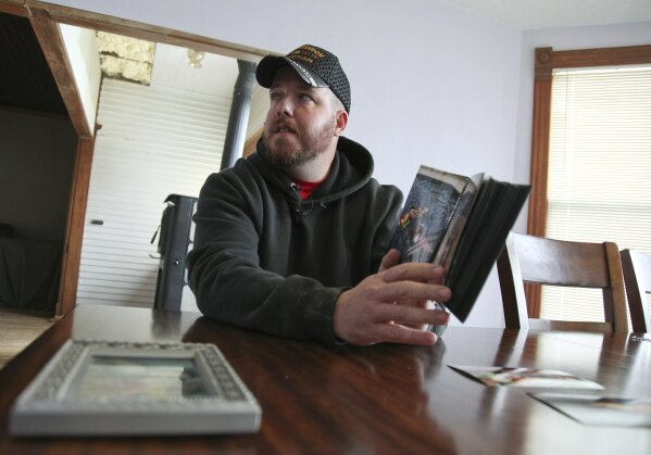 In this Nov. 1, 2019, photo, Gabe Steele holds a photo album in his home in West Point, Iowa, and talks about the accidental fatal shooting of his wife, Autumn Steele, by a Burlington, Iowa police officer in 2015. Accidental shootings by police happen across the United States every year, an Associated Press investigation has found, and experts say it's because law enforcement officers don't get the training they need. (AP Photo/Matthew Holst)