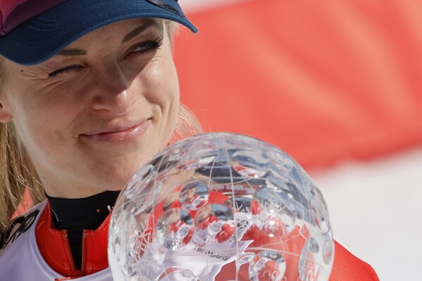 Switzerland's Lara Gut Behrami holds the trophy for the alpine ski, women's World Cup super-G discipline, in Saalbach, Austria, Friday, March 22, 2024. (AP Photo/Alessandro Trovati)