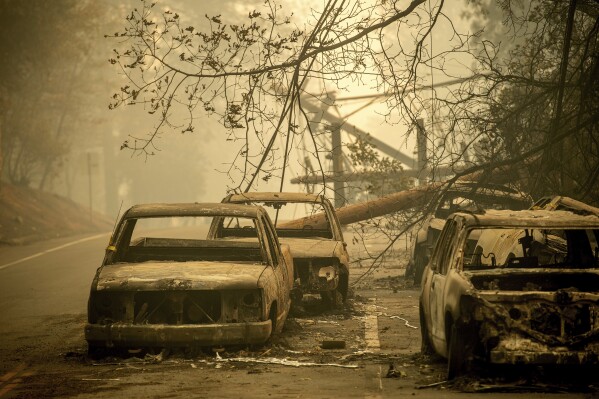 FILE - Abandoned cars, scorched by the wildfire, line Pearson Rd. in Paradise, Calif., on Saturday, Nov. 10, 2018. Currently, the Maui wildfires are the nation's fifth-deadliest on record, according to research by the National Fire Protection Association, a nonprofit that publishes fire codes and standards used in the U.S. and around the world. The Camp Fire killed 85 people and forced tens of thousands of others to flee their homes as flames destroyed 19,000 buildings in Northern California.(AP Photo/Noah Berger, File)