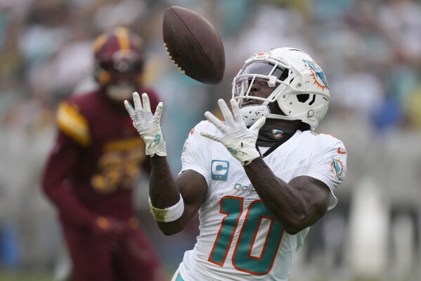 FILE - Miami Dolphins wide receiver Tyreek Hill (10) catches a touchdown pass during the first half of an NFL football game against the Washington Commanders Sunday, Dec. 3, 2023, in Landover, Md. (AP Photo/Mark Schiefelbein, File(