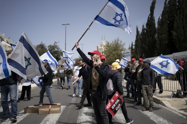 FILE - Members of Brothers and Sisters in Arms and Bonot Alternativa (Women Building an Alternative) protest Israel's exemptions for ultra-Orthodox Jews from mandatory military service, near the Prime Minister's office in Jerusalem, on March 26, 2024. (AP Photo/Maya Alleruzzo, File)