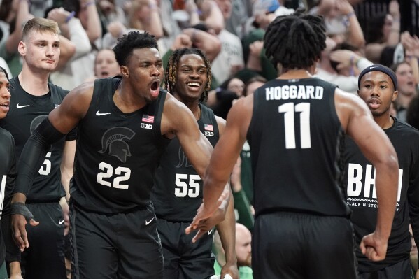 Michigan State guard A.J. Hoggard (11) is cheered on by center Mady Sissoko (22) and teammates after a play during the first half of an NCAA college basketball game against Illinois, Saturday, Feb. 10, 2024, in East Lansing, Mich. (AP Photo/Carlos Osorio)
