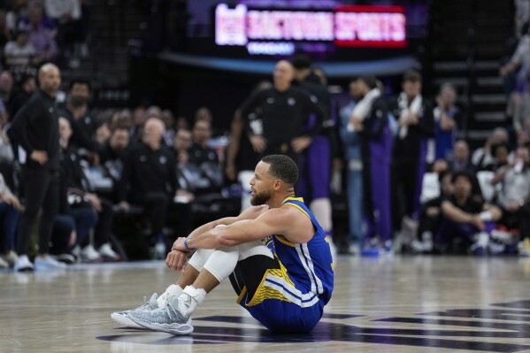 Golden State Warriors guard Stephen Curry sits on the court during the second half of the team's NBA basketball play-in tournament game against the Sacramento Kings, Tuesday, April 16, 2024, in Sacramento, Calif. (AP Photo/Godofredo A. Vásquez)