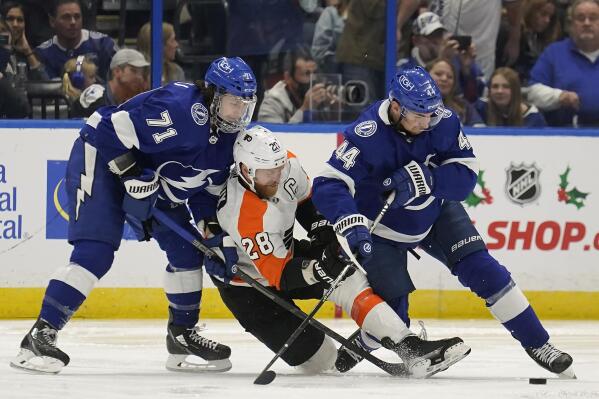 Tampa Bay Lightning center Anthony Cirelli (71) and defenseman Jan Rutta (44) team up to sandwich Philadelphia Flyers center Claude Giroux (28) during the second period of an NHL hockey game Tuesday, Nov. 23, 2021, in Tampa, Fla. (AP Photo/Chris O'Meara)