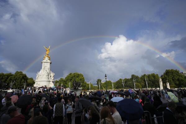 People gather outside Buckingham Palace in London as a double rainbow appears in the sky, Thursday, Sept. 8, 2022. Buckingham Palace says Queen Elizabeth II has been placed under medical supervision because doctors are "concerned for Her Majesty's health." Members of the royal family traveled to Scotland to be with the 96-year-old monarch. (AP Photo/Frank Augstein)