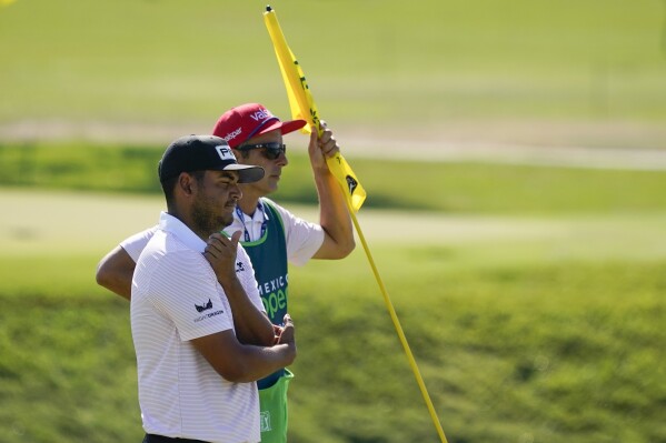 FILE - Sebastian Munoz, of Colombia, and his caddie, Jose Campra, stand at the first hole during the final round of the Mexico Open at Vidanta in Puerto Vallarta, Mexico, Sunday, May 1, 2022. More than just a caddie, Campra is a teacher who helped Camilo Villegas get his game on track.(AP Photo/Eduardo Verdugo, File)