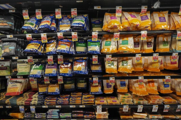 Cheese products in plastic packaging line the cooler at a grocery store in New Orleans, Wednesday, April 17, 2024. People are increasingly breathing, eating and drinking tiny particles of plastic, however, there are simple things people can do at the grocery store if they want to use less plastic. (AP Photo/Gerald Herbert)