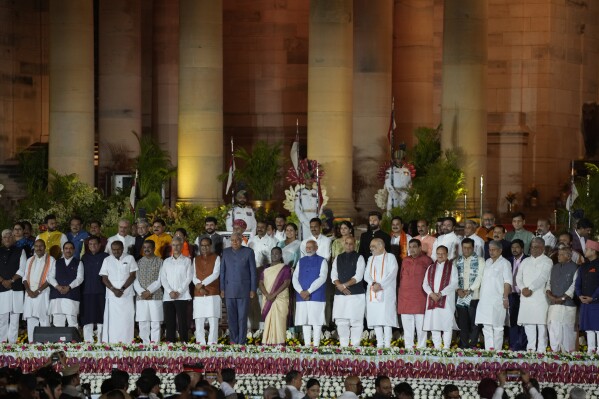 Wiceprezydent Indii Jagdeep Dhankhar (w środku po lewej), prezydent Indii Draupadi Murmu (w środku) i premier Indii Narendra Modi w niebieskiej kamizelce pozują do grupowego zdjęcia z nowym ministrem stanu i nowym ministrem stanu podczas zaprzysiężenia – ceremonia w indyjskim Rashtrapati Bhavan w New Delhi, Indie, niedziela, 9 czerwca 2024 r. (AP Photo/Manish Swarup)