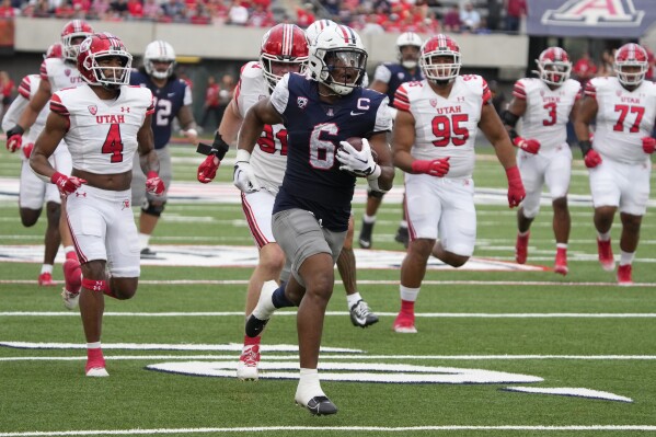 Arizona running back Michael Wiley (6) scores a touchdown against Utah during the first half of an NCAA college football game, Saturday, Nov. 18, 2023, in Tucson, Ariz. (AP Photo/Rick Scuteri)