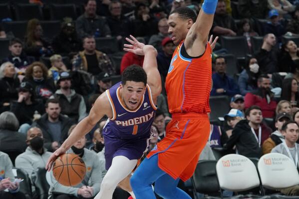 Phoenix Suns guard Devin Booker (1) drives around Oklahoma City Thunder forward Darius Bazley (7) in the second half of an NBA basketball game Thursday, Feb. 24, 2022, in Oklahoma City. (AP Photo/Sue Ogrocki)