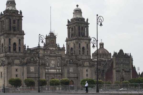 A lone policeman stands watch at Mexico City's main square known as the Zocalo which has been closed to pedestrian traffic to encourage people to stay home as a measure to curb the spread of the new coronavirus, Saturday, May 16, 2020. (AP Photo/Christian Palma)