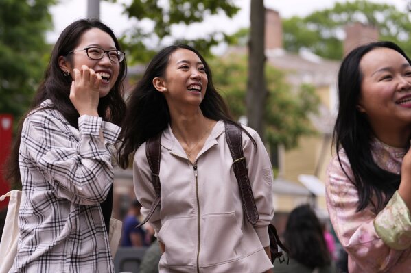 Yurong "Luanna" Jiang, center, who delivered a speech at her Harvard University commencement, jokes with her college friends Helen Ji, left, and Cynthia Luo, Friday, May 30, 2025, in Cambridge, Mass. (AP Photo/Charles Krupa)