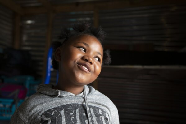 Lilitha Jiphethu, 11, sings in her first language, Xhosa, inside her home in Orange Farm, South Africa, on Tuesday, April 28, 2020. “I have a friend in Jesus. He is loving and he’s not like any other friend. He is not deceitful. He is not ashamed of us. He is truthful, and He is love.” (AP Photo/Denis Farrell)