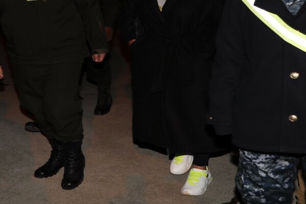 Bolivia's former interim President Jeanine Anez, center, who has been detained, is escorted by Government Minister Carlos Eduardo Del Castillo, second from right, and Bolivian Police Commander Jhonny Aguilera at the military airport in El Alto, Bolivia, Saturday, March 13, 2021. Prosecutors ordered the arrest Anez and several former ministers for sedition. (AP Photo/Juan Karita)