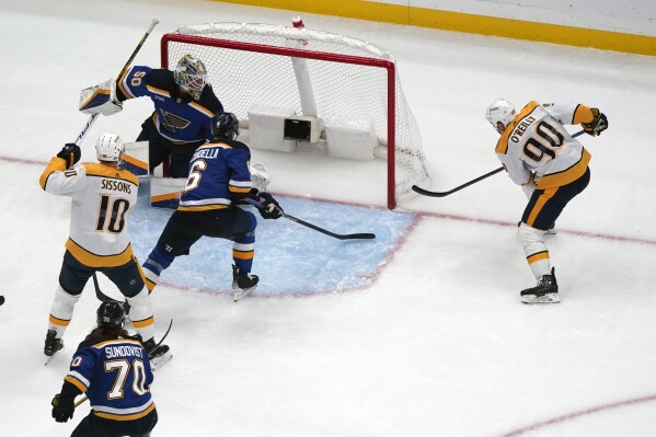 CORRECTS TO SECOND PERIOD NOT FIRST PERIOD - Nashville Predators' Ryan O'Reilly (90) scores past St. Louis Blues goaltender Jordan Binnington (50) during the second period of an NHL hockey game on Friday, Nov. 24, 2023, in St. Louis. (AP Photo/Jeff Roberson)