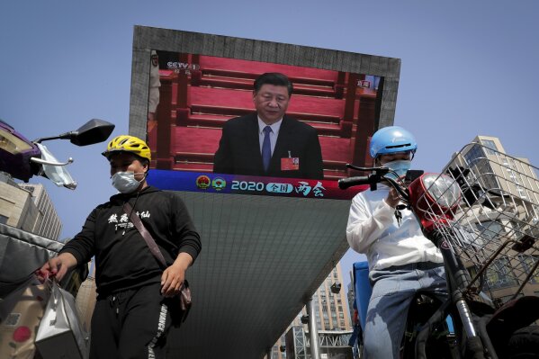 Food delivery workers wearing face masks to protect against the spread of the new coronavirus prepare to delivery foods near a TV screen showing Chinese President Xi Jinping attending the closing ceremony of the National People's Congress in a news report, in Beijing, China, Thursday, May 28, 2020. China's ceremonial legislature on Thursday endorsed a national security law for Hong Kong that has strained relations with the United States and Britain. (AP Photo/Andy Wong)