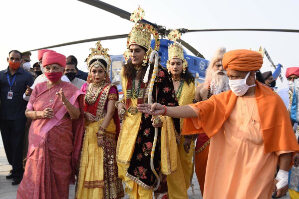 Uttar Pradesh state Governor Anandiben Patel, left, and  Chief Minister Yogi Adityanath receive artists dressed  as Hindu god Ram, goddess Sita and Lakshman as they alight from a helicopter on the banks of river Saryu on the eve of Diwali, the Hindu festival of lights, in Ayodhya, India, Friday, Nov. 13, 2020. Diwali will be celebrated on Saturday. (AP Photo/Rajeev Bhatt)