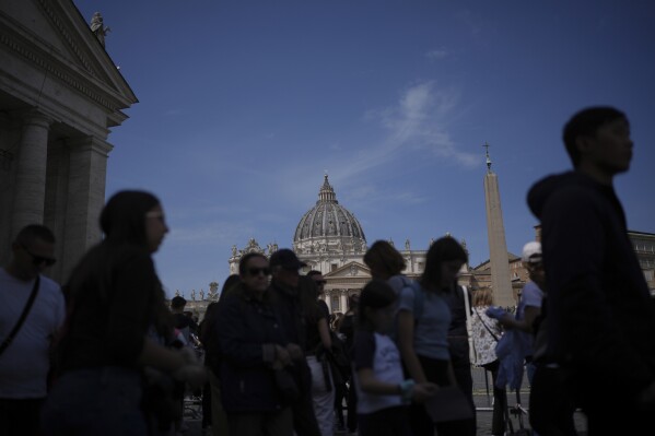 People gather in St. Peter's Square at the Vatican after the Vatican announced the death of Pope Francis, Monday, April 21, 2025. (AP Photo/Alessandra Tarantino)