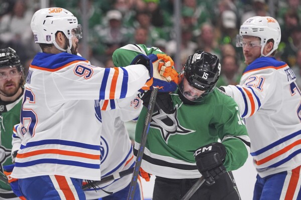 Dallas Stars center Colin Blackwell (15) tussles with Edmonton Oilers defenseman Jake Walman (96) and center Trent Frederic (21) during the first period in Game 2 of the Western Conference finals in the NHL hockey Stanley Cup playoffs Friday, May 23, 2025, in Dallas. (AP Photo/LM Otero)