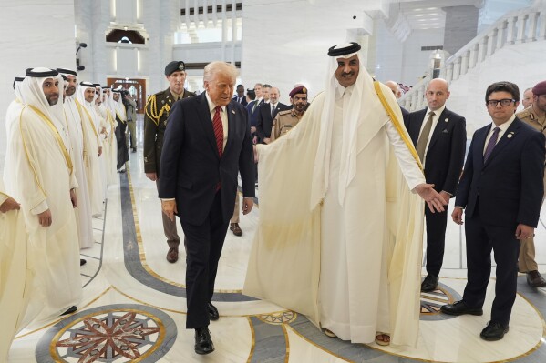 Qatar's Emir Sheikh Tamim bin Hamad Al Thani welcomes President Donald Trump during an official welcoming ceremony at the Amiri Diwan in Doha, Qatar, Wednesday, May 14, 2025. (AP Photo/Alex Brandon)