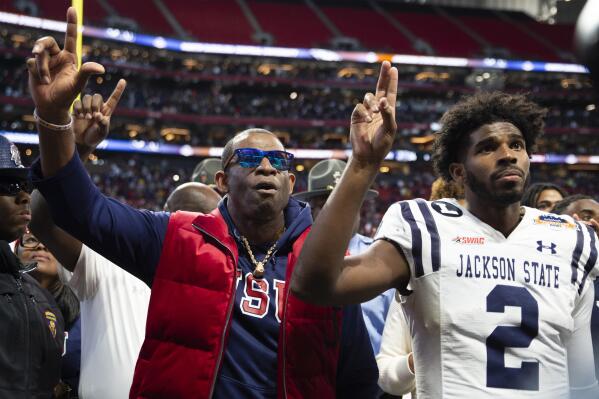 Jackson State head coach Deion Sanders, left, and his son quarterback Shedeur Sanders sing the school's alma mater after the Celebration Bowl NCAA college football game nst North Carolina Central, Saturday, Dec. 17, 2022, in Atlanta. (AP Photo/Hakim Wright Sr. )