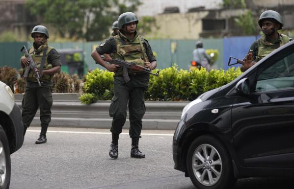 Sri Lankan army soldiers man a check point outside the prime minister's residence in Colombo, Sri Lanka, Tuesday, May 10, 2022. Defying a nationwide curfew in Sri Lanka, several hundred protesters continued to chant slogans against the government Tuesday, a day after violent clashes saw the resignation of the prime minister who is blamed, along with his brother, the president, for leading the country into its worst economic crisis in decades.(AP Photo/Eranga Jayawardena)
