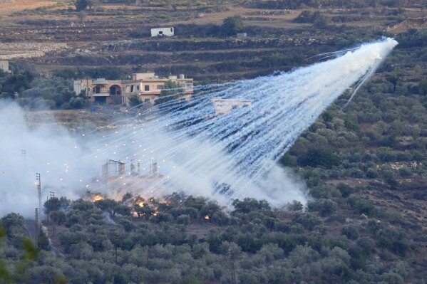 FILE - A shell that appears to be white phosphorus from Israeli artillery explodes over a house in al-Bustan, a Lebanese village along the border with Israel, on Oct. 15, 2023. A global human rights group claimed in a report published Wednesday, June 5, 204, that Israel has used white phosphorus incendiary shells on residential buildings in at least five towns and villages in conflict-hit southern Lebanon, possibly harming civilians and violating international law. (AP Photo/Hussein Malla, File)